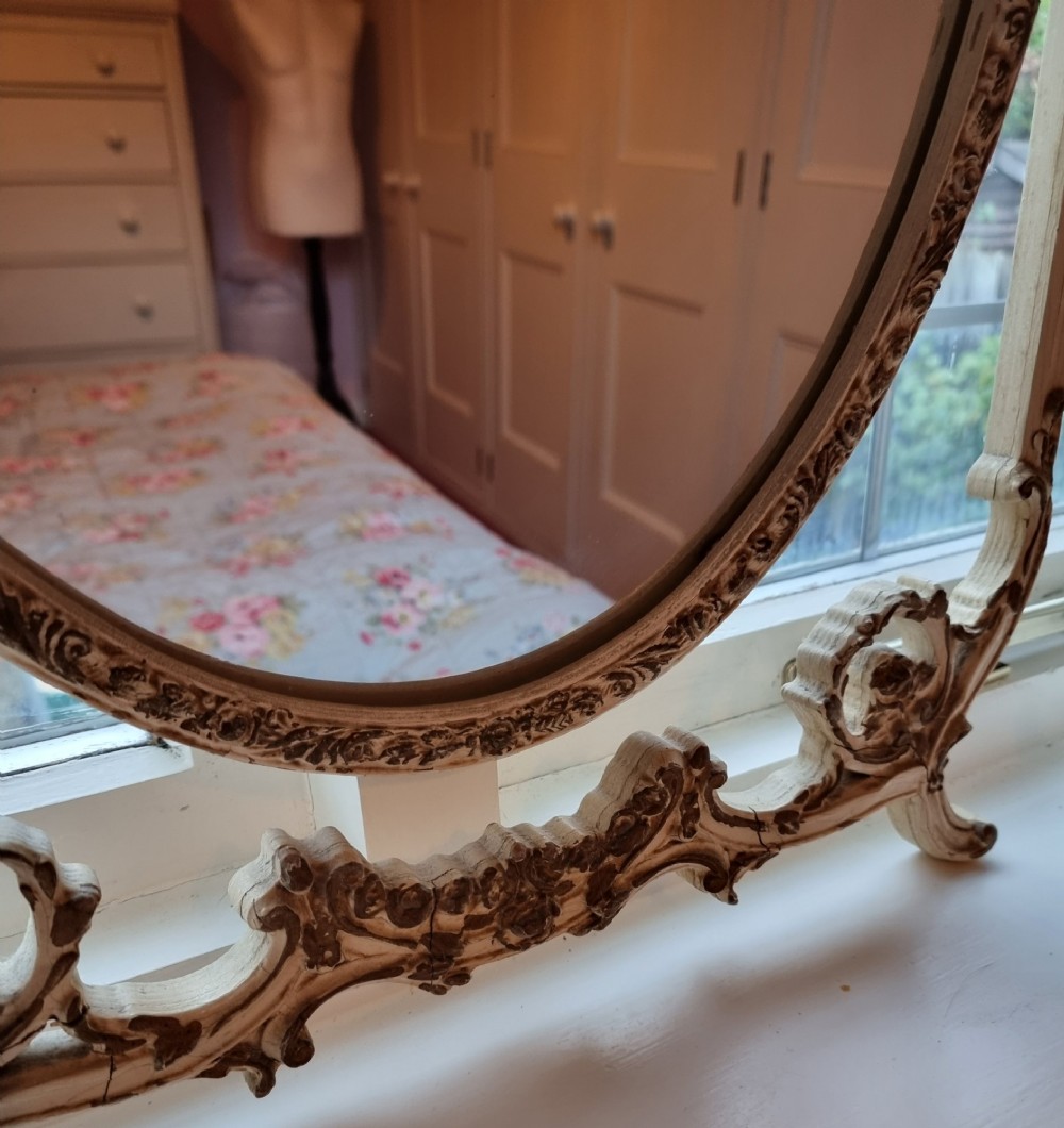 A 1930s cream-painted triple vanity mirror featuring three oval glass panels set in ornate scrollwork frames. View VI