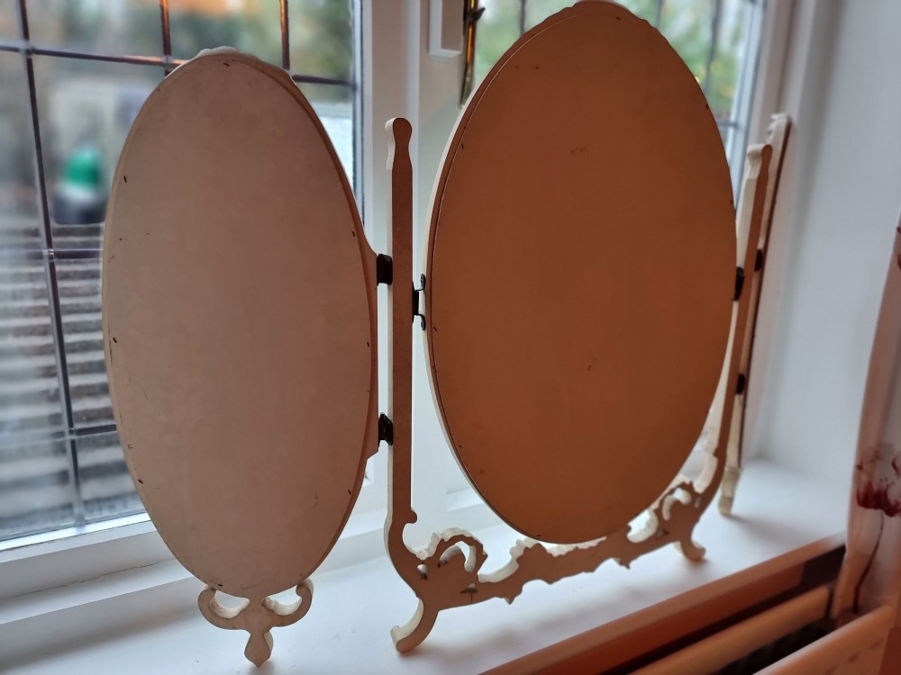 A 1930s cream-painted triple vanity mirror featuring three oval glass panels set in ornate scrollwork frames. View IX
