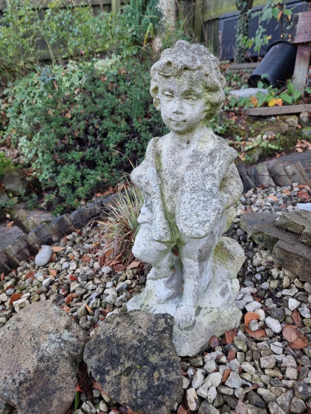 A pair of weathered grey reconstituted stone garden statues depicting classical musical cherubs holding instruments. View VIII