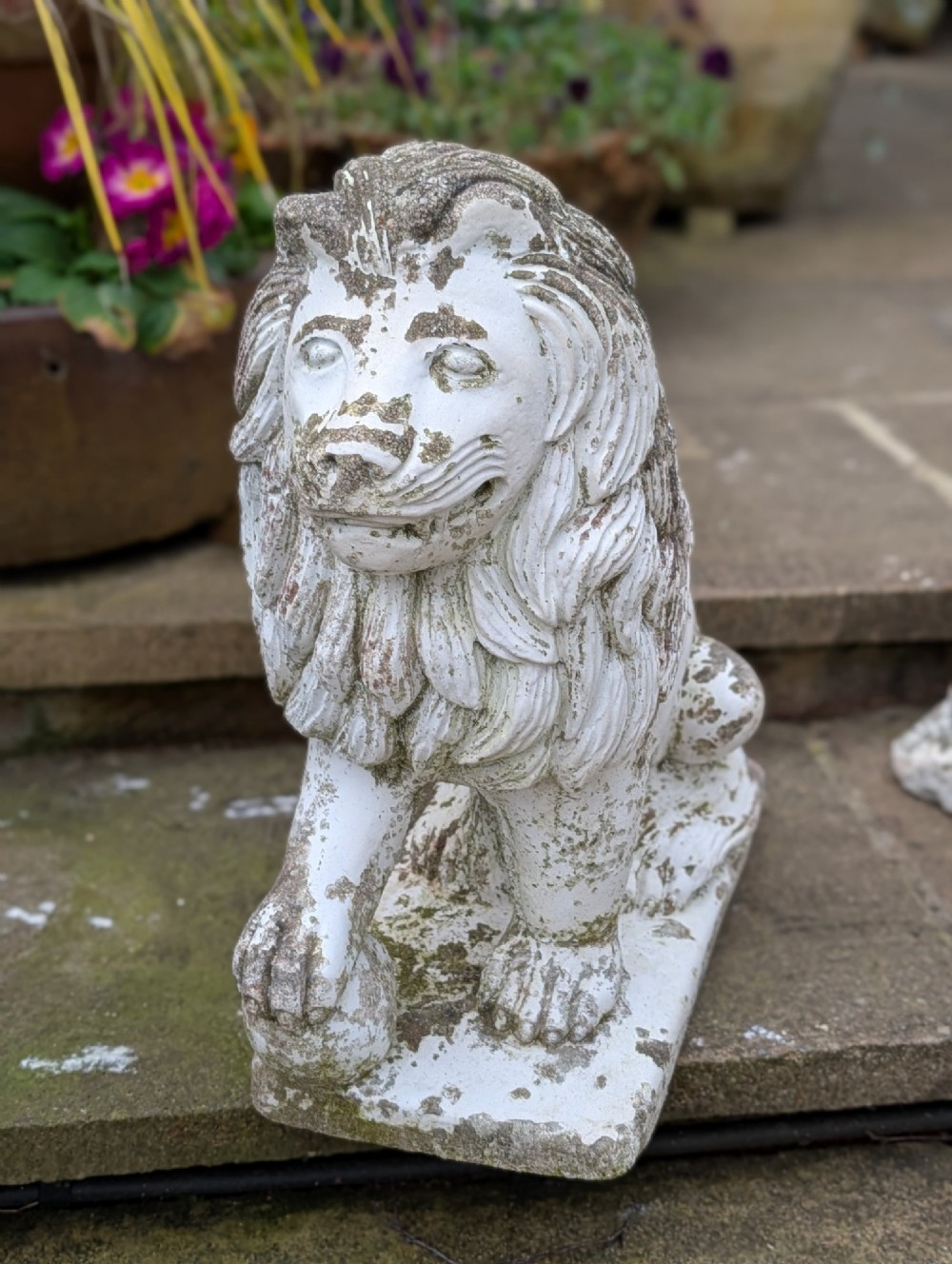 A pair of 19th-century French weathered off-white cast stone Medici lion statues seated on rectangular plinths, each resting a paw on a sphere. View VI