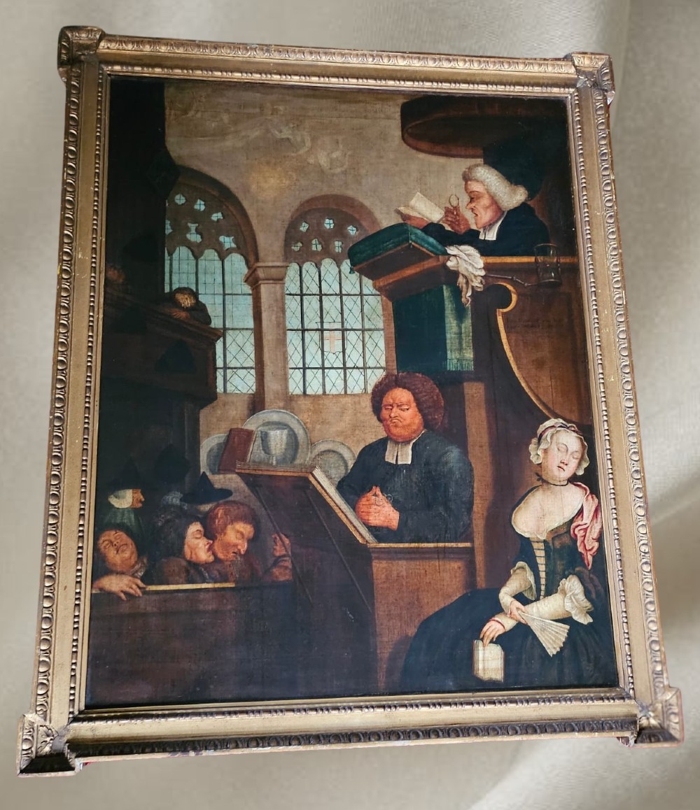 An antique framed oil painting depicting a clergyman speaking to a sleeping congregation inside an eighteenth-century church interior.