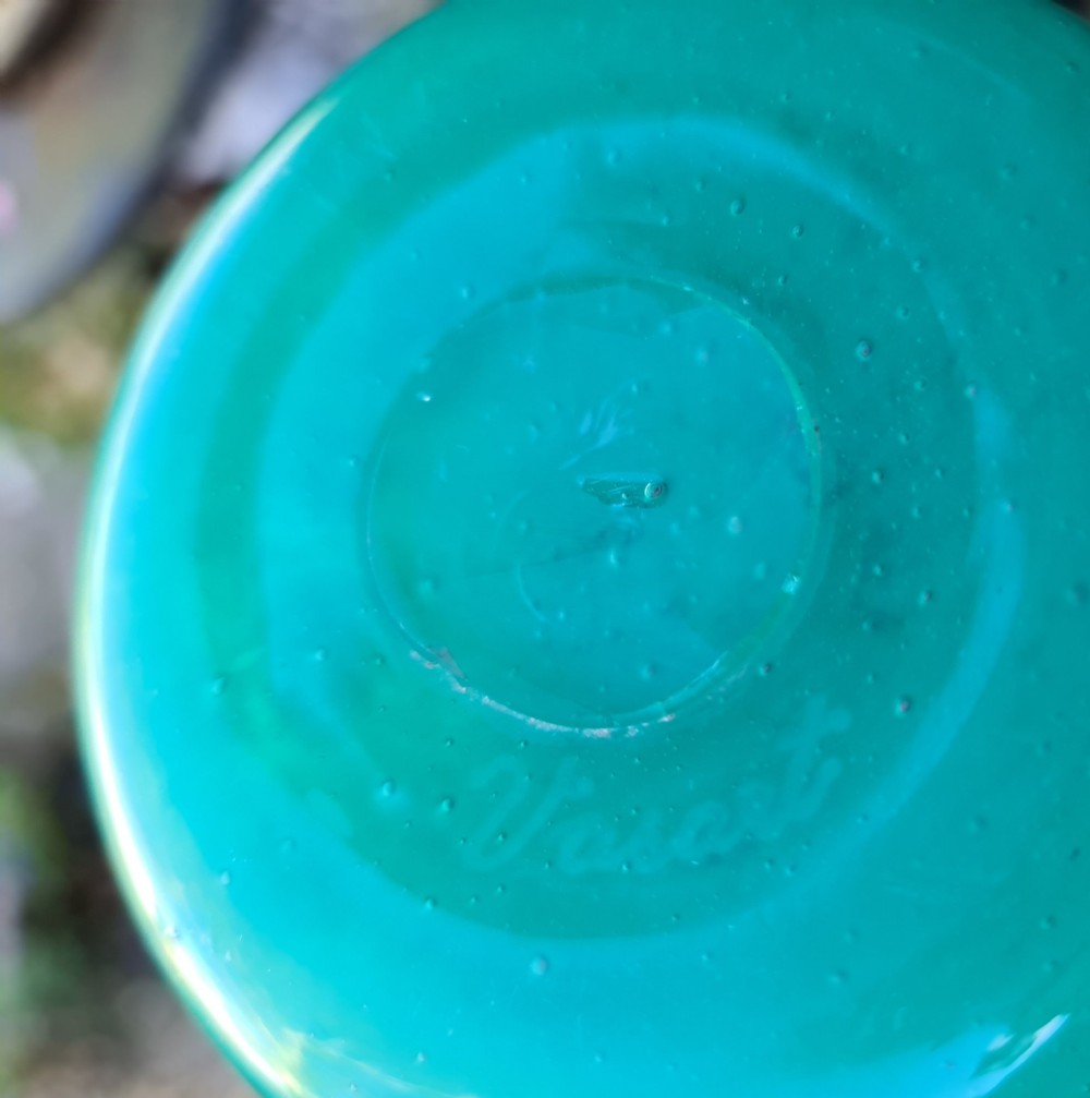 A rounded emerald green blown glass vase featuring a dark mottled rim, flared lip, and suspended gold aventurine flecks. View VIII