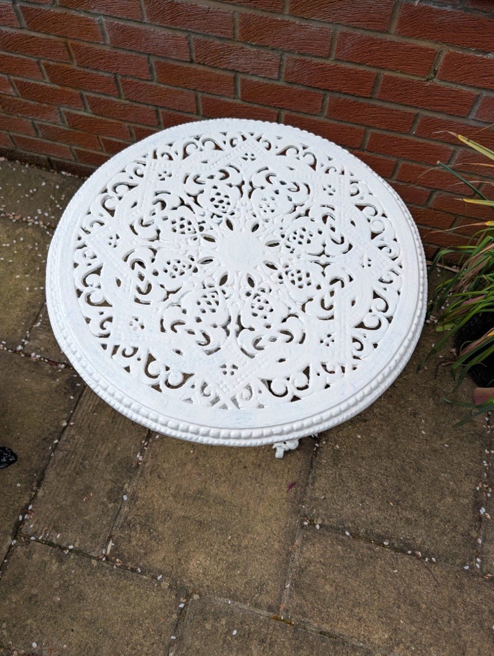 A white painted Victorian cast-iron garden bistro table featuring an intricately pierced circular top supported by an ornate tri-form pedestal base. View III