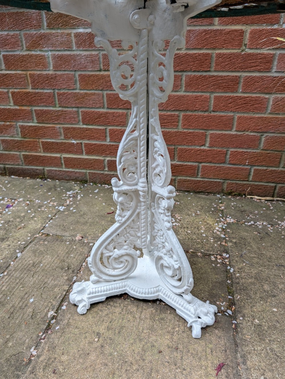 A white painted Victorian cast-iron garden bistro table featuring an intricately pierced circular top supported by an ornate tri-form pedestal base. View IV