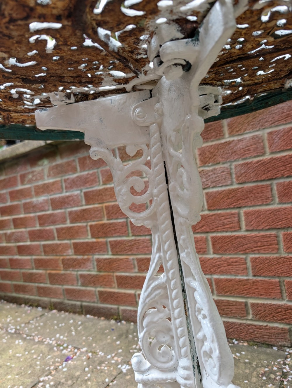 A white painted Victorian cast-iron garden bistro table featuring an intricately pierced circular top supported by an ornate tri-form pedestal base. View VII