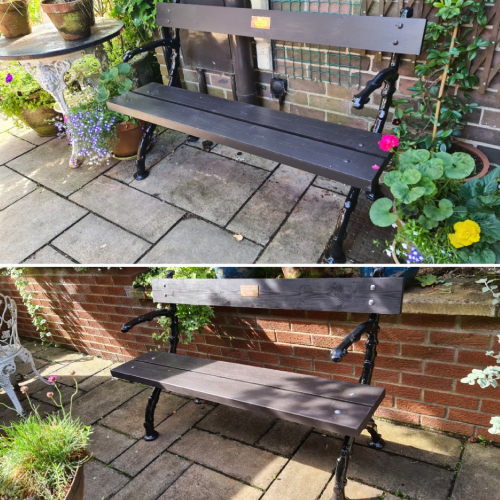 A 19th-century garden bench featuring black cast-iron branch-form legs and dark wooden seat and backrest slats. View V