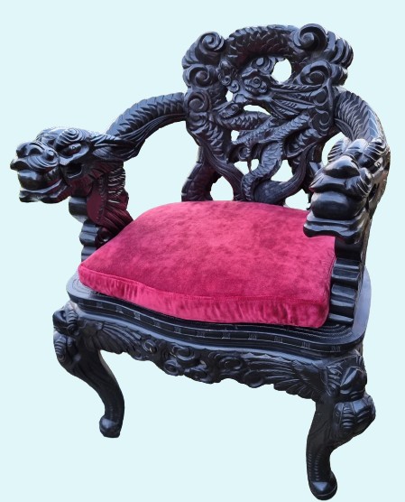 A deeply carved black hardwood armchair featuring dragon head armrests, a dragon backrest, and a red velvet seat cushion.