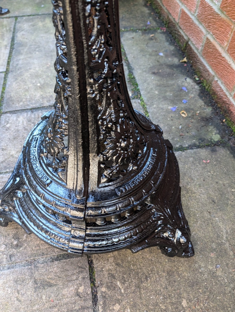 A Victorian cast-iron garden set featuring a circular copper-topped pedestal table surrounded by four ornate black cast-iron chairs with foliage-patterned backrests. View VIII