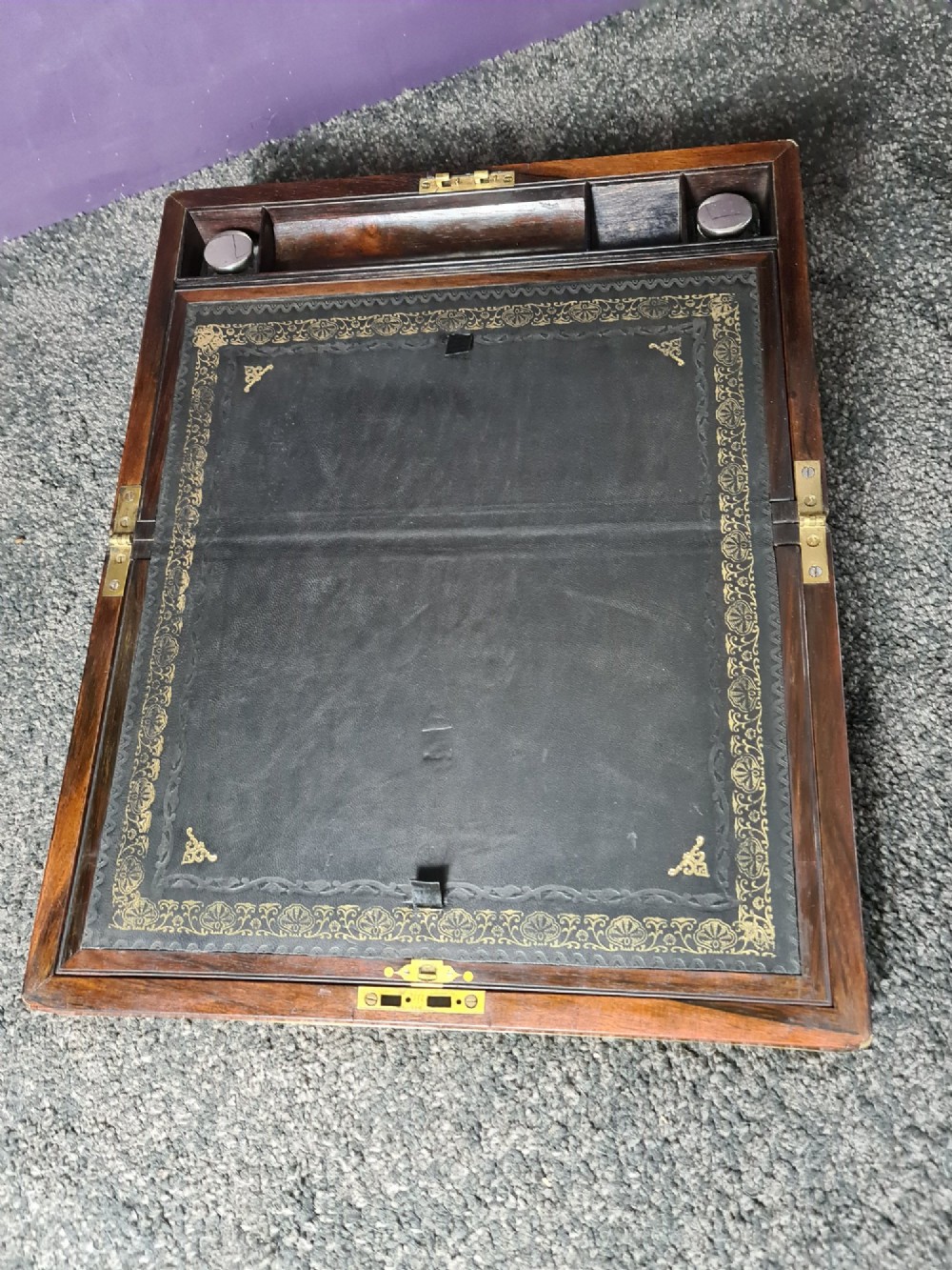 A rectangular rosewood box featuring brass edge binding, inlaid brass stringing, a brass escutcheon, and a tassel key inserted in the lock. View II
