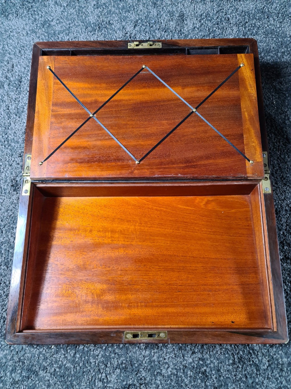 A rectangular rosewood box featuring brass edge binding, inlaid brass stringing, a brass escutcheon, and a tassel key inserted in the lock. View VII