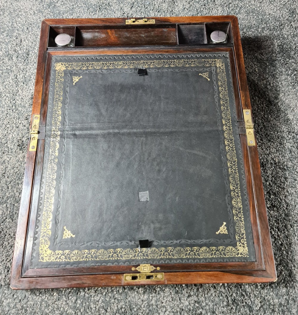 A rectangular rosewood box featuring brass edge binding, inlaid brass stringing, a brass escutcheon, and a tassel key inserted in the lock. View VIII