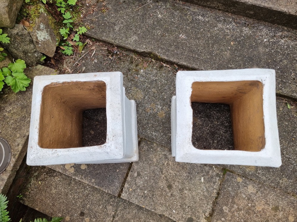 A pair of 19th-century square white-painted terracotta chimney pot pedestals with moulded rims resting on outdoor stone steps. View VI