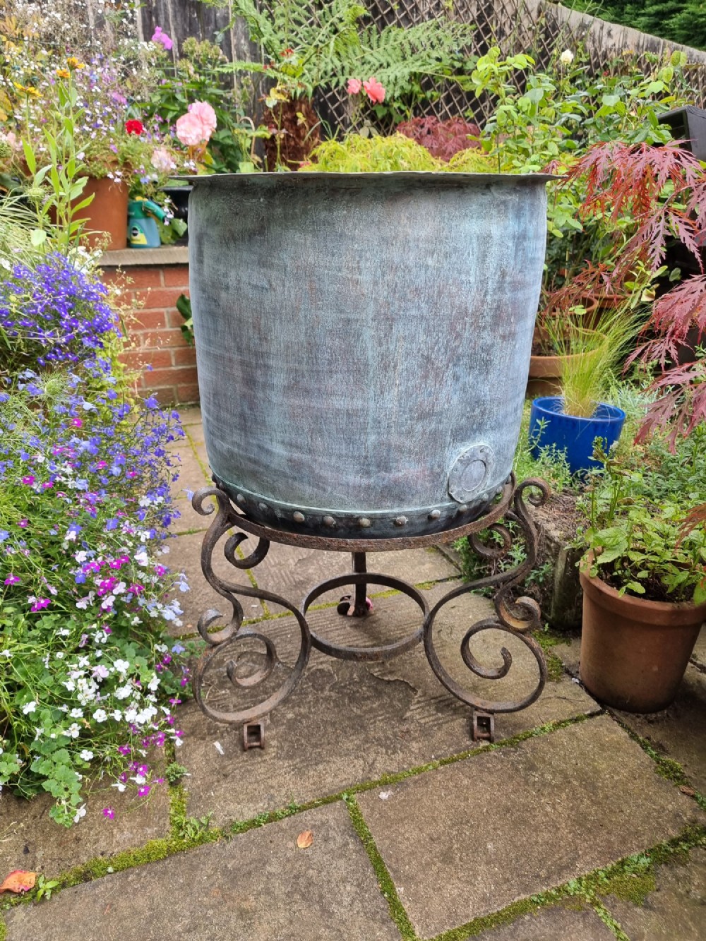 A large cylindrical French copper garden pot featuring a flared rolled rim, hand-riveted base seam, and a naturally weathered verdigris patina. View II