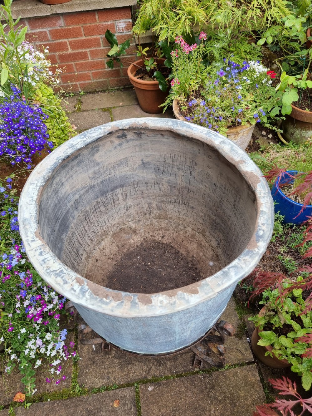 A large cylindrical French copper garden pot featuring a flared rolled rim, hand-riveted base seam, and a naturally weathered verdigris patina. View V
