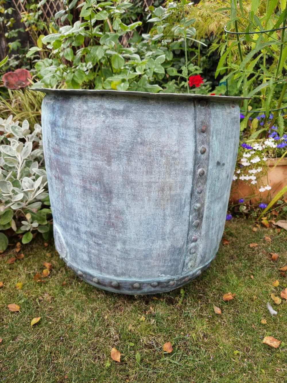 A large cylindrical French copper garden pot featuring a flared rolled rim, hand-riveted base seam, and a naturally weathered verdigris patina. View VIII