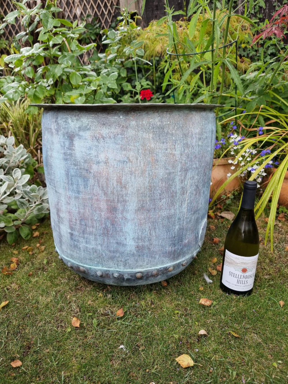 A large cylindrical French copper garden pot featuring a flared rolled rim, hand-riveted base seam, and a naturally weathered verdigris patina. View XI