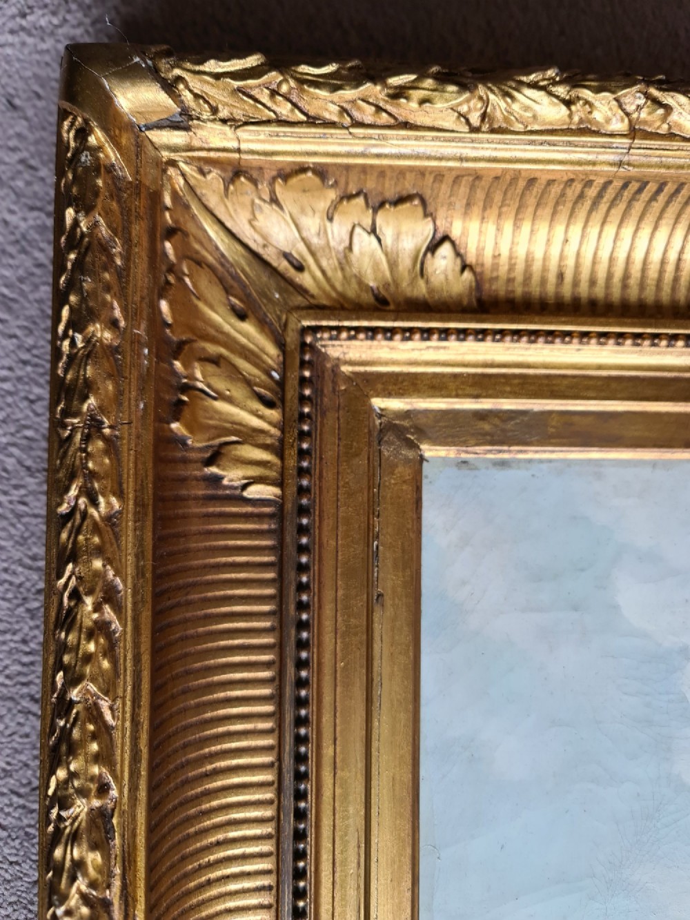 An oil painting depicting a Rococo pastoral scene with figures and sheep by a stream, set within a heavy gilded frame. View VII