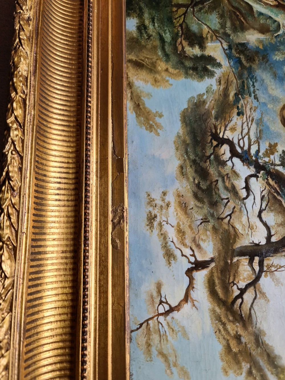 An oil painting depicting a Rococo pastoral scene with figures and sheep by a stream, set within a heavy gilded frame. View XI