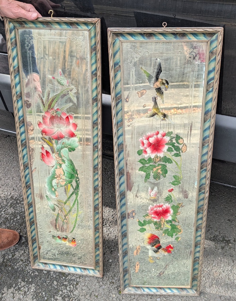 A pair of rectangular Chinese reverse-painted wall mirrors featuring floral, bird, and rooster illustrations against a distressed silvered glass background with striped frames.
