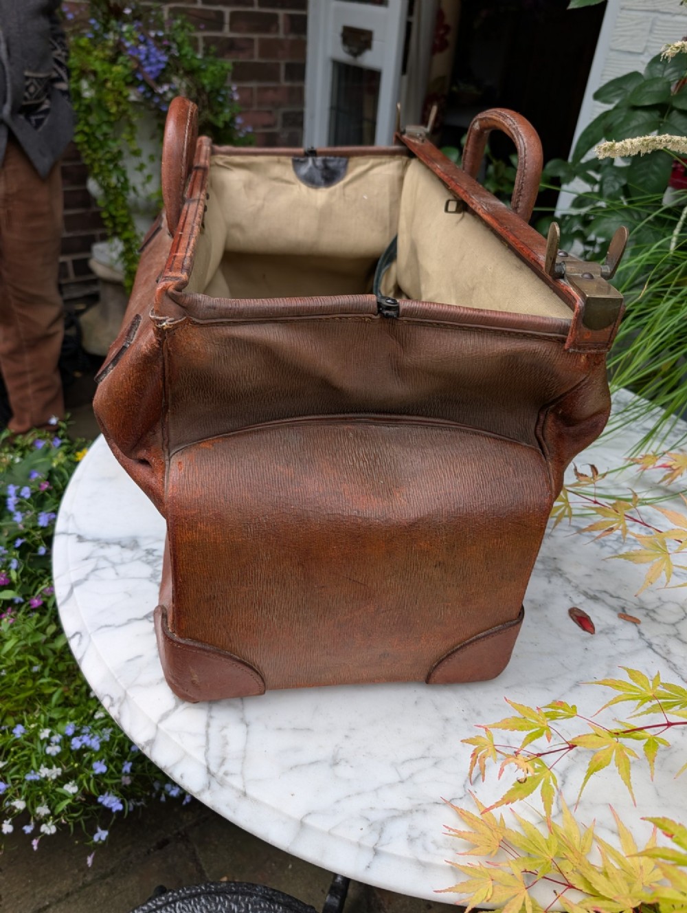 A Victorian brown leather Gladstone travel bag with a central brass lever lock and twin stitched handles. View XI