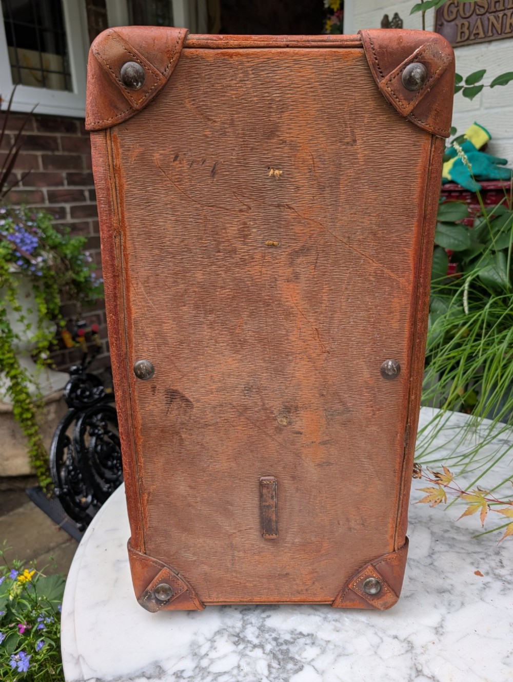 A Victorian brown leather Gladstone travel bag with a central brass lever lock and twin stitched handles. View XII