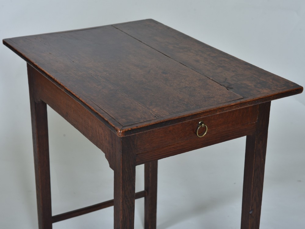 An 18th-century dark oak side table featuring a single frieze drawer with a small brass ring pull, straight square legs, and lower H-stretchers. View II