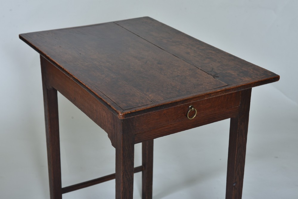 An 18th-century dark oak side table featuring a single frieze drawer with a small brass ring pull, straight square legs, and lower H-stretchers. View III