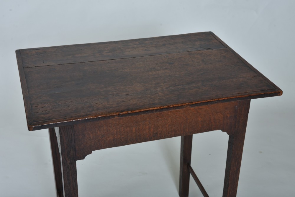 An 18th-century dark oak side table featuring a single frieze drawer with a small brass ring pull, straight square legs, and lower H-stretchers. View VI