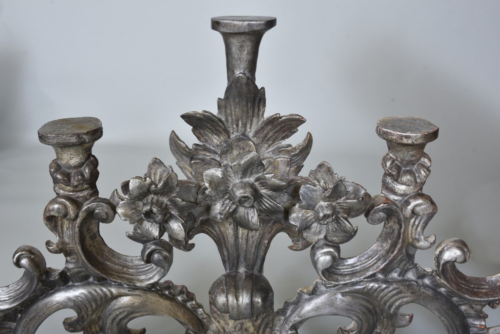An 18th-century Italian carved wooden pediment finished in aged silver leaf featuring floral motifs, acanthus scrollwork, and raised pedestals. View II
