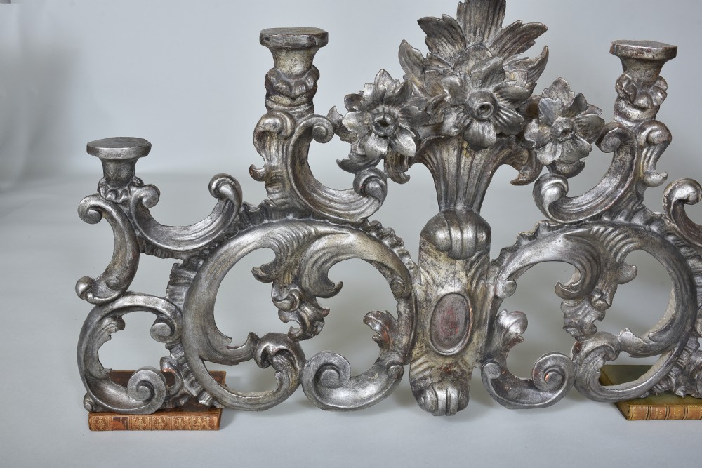 An 18th-century Italian carved wooden pediment finished in aged silver leaf featuring floral motifs, acanthus scrollwork, and raised pedestals. View VII