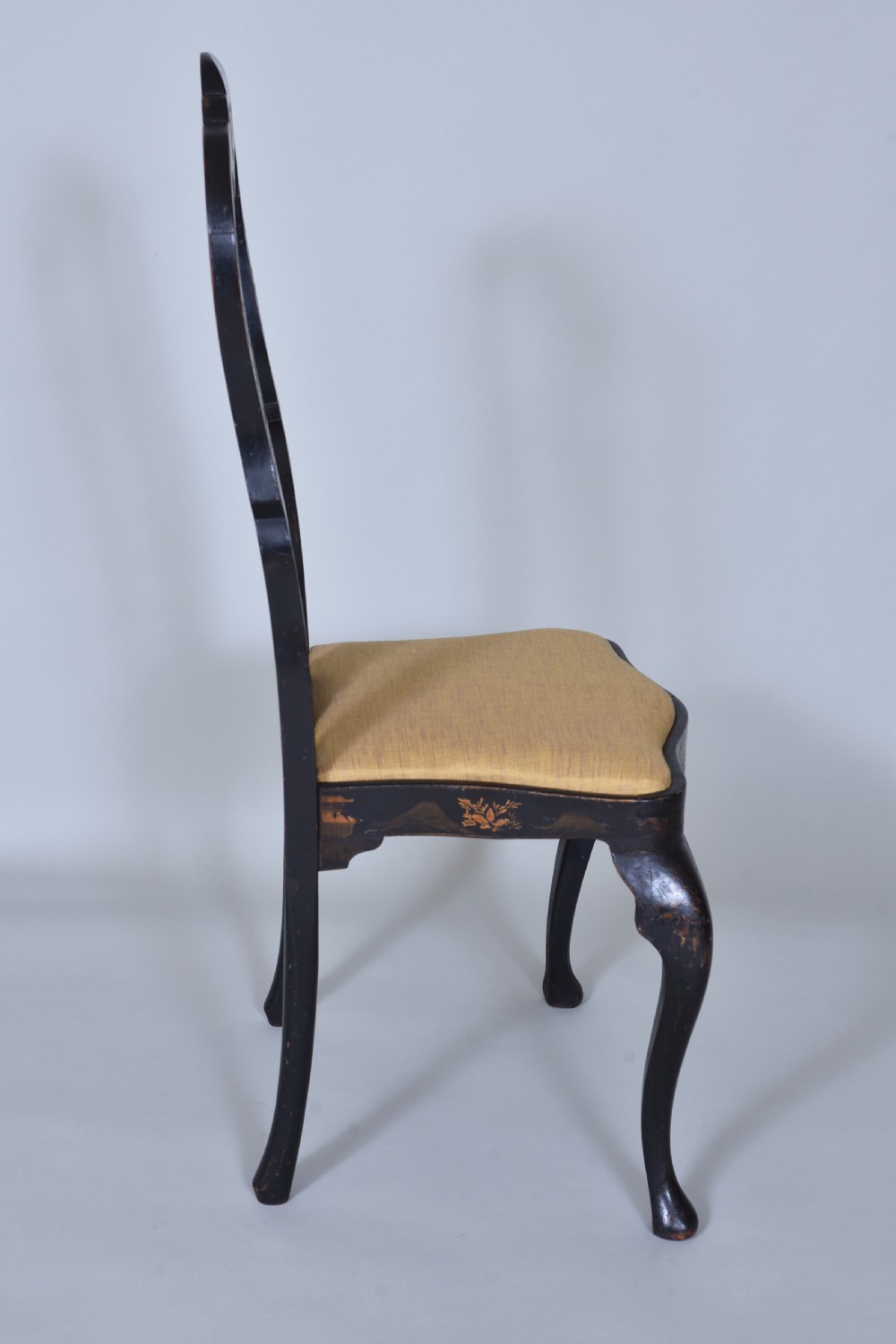 A pair of black lacquered Queen Anne style side chairs featuring vasiform splats, hand-painted gold Chinoiserie patterns, cabriole front legs, and yellow upholstered drop-in seats. View IX
