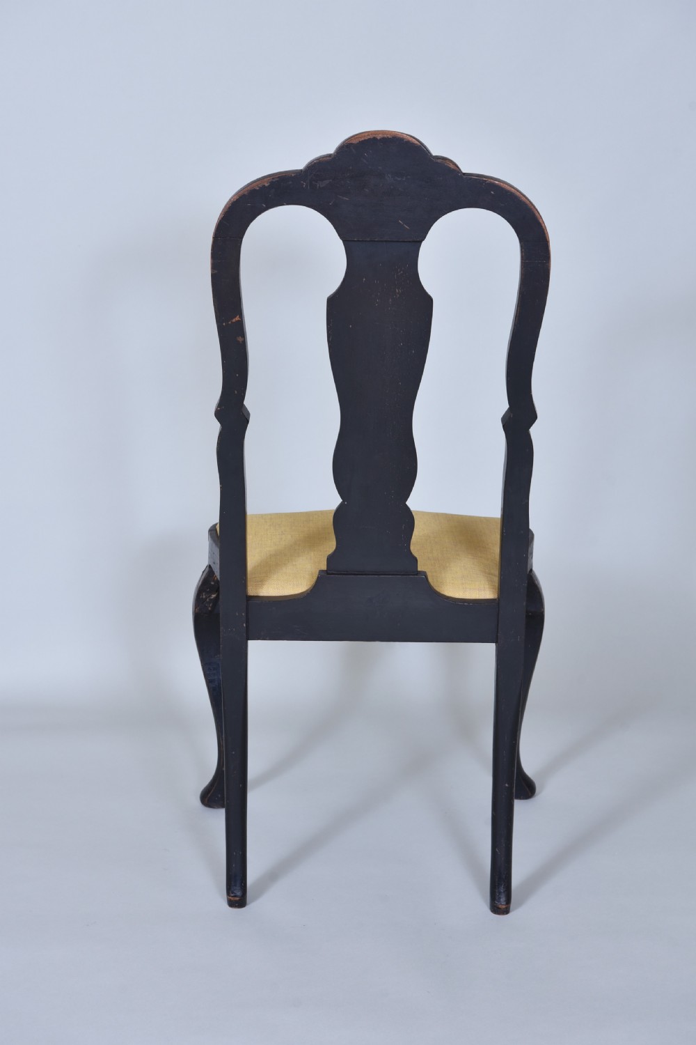 A pair of black lacquered Queen Anne style side chairs featuring vasiform splats, hand-painted gold Chinoiserie patterns, cabriole front legs, and yellow upholstered drop-in seats. View X