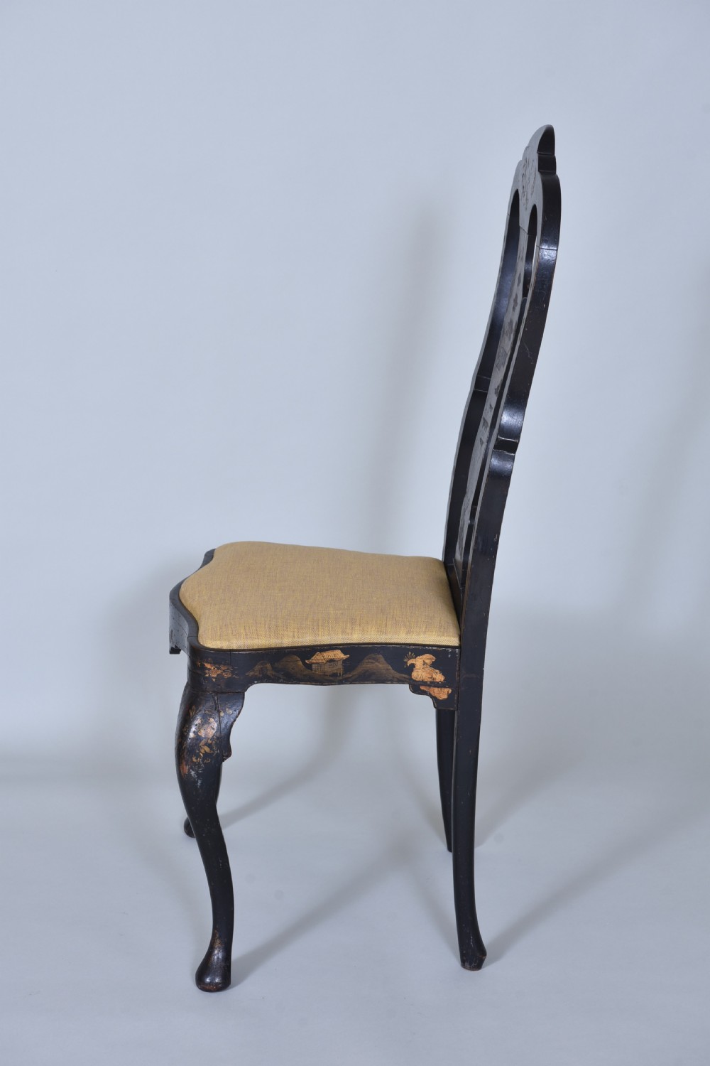 A pair of black lacquered Queen Anne style side chairs featuring vasiform splats, hand-painted gold Chinoiserie patterns, cabriole front legs, and yellow upholstered drop-in seats. View XI