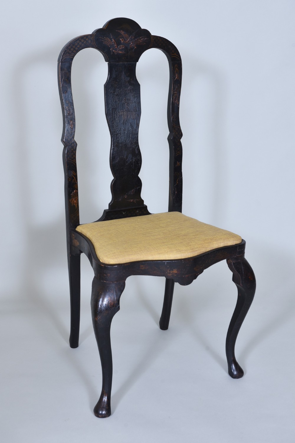 A pair of black lacquered Queen Anne style side chairs featuring vasiform splats, hand-painted gold Chinoiserie patterns, cabriole front legs, and yellow upholstered drop-in seats. View XII