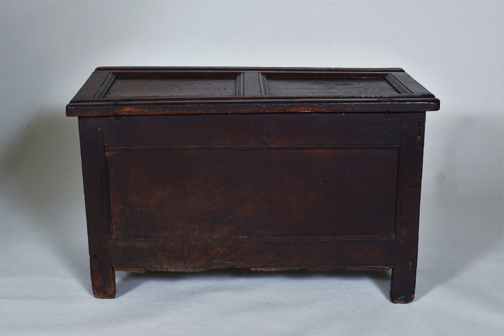 A dark oak 17th-century coffer featuring a carved fluted upper frieze, twin front panels, and a central iron lock plate. View XI
