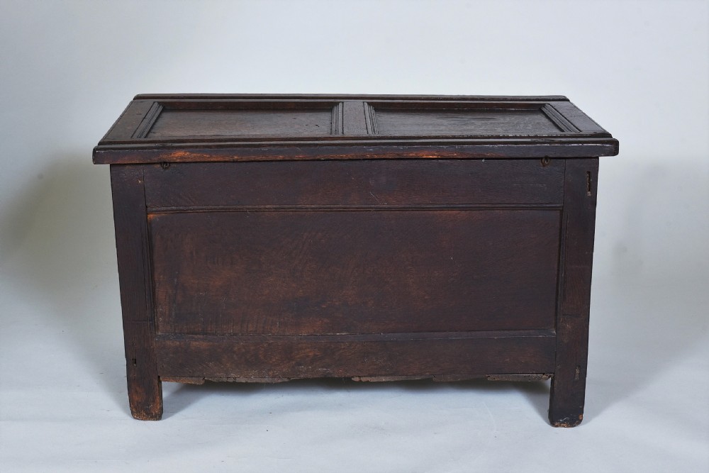 A dark oak 17th-century coffer featuring a carved fluted upper frieze, twin front panels, and a central iron lock plate. View XII