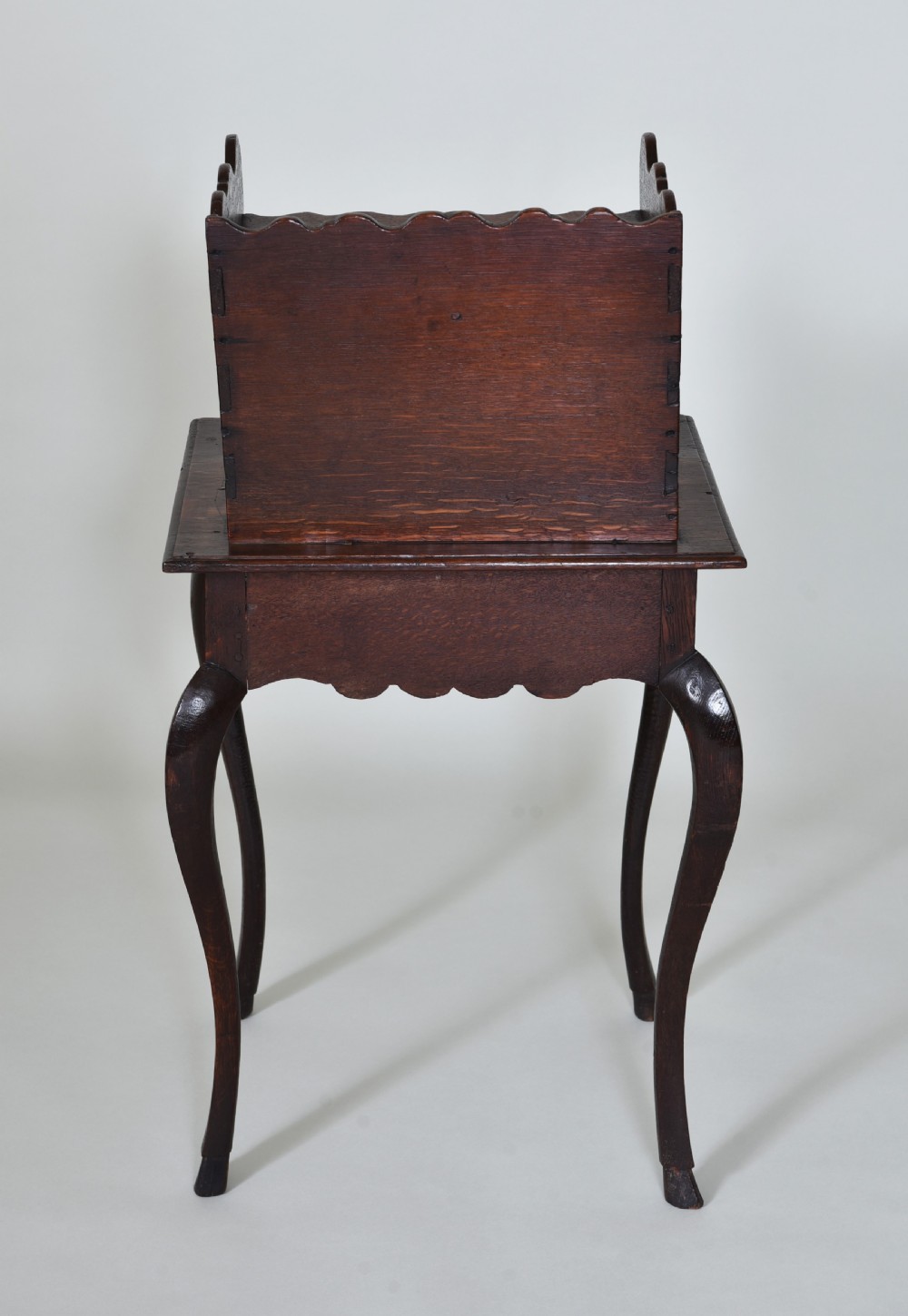 An 18th-century dark oak side table featuring curved cabriole legs, a scalloped apron, and a raised two-tier scalloped gallery shelf. View II