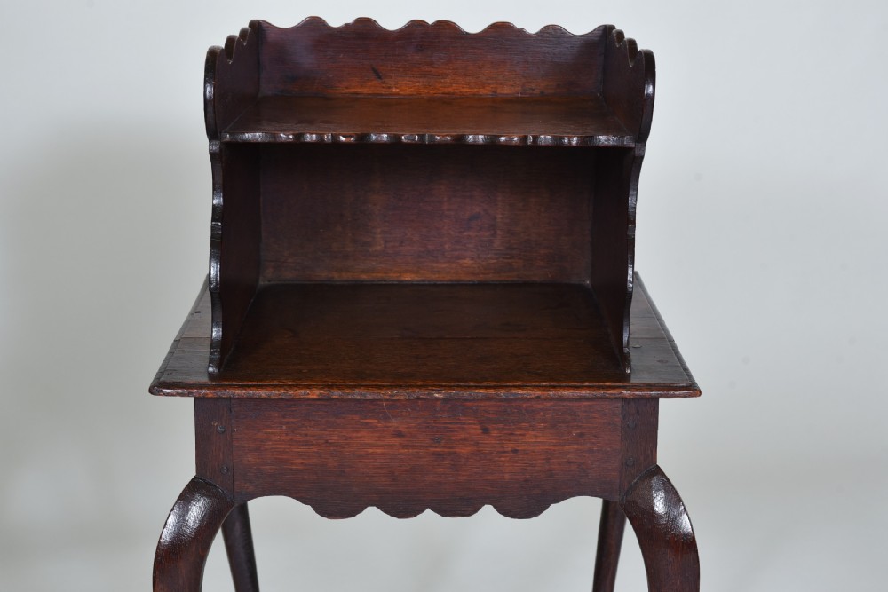 An 18th-century dark oak side table featuring curved cabriole legs, a scalloped apron, and a raised two-tier scalloped gallery shelf. View III