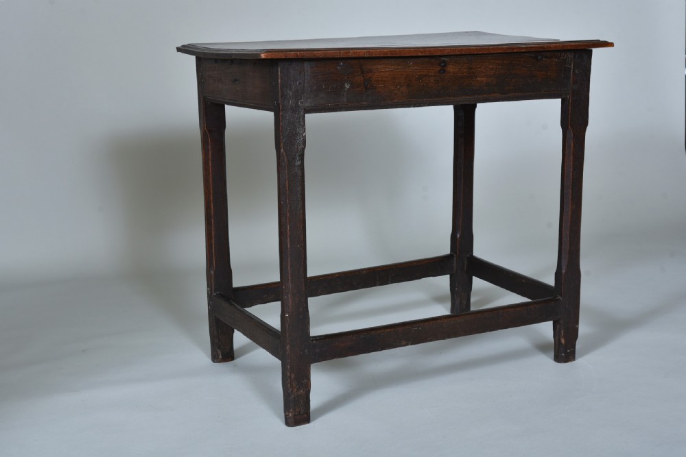 An early eighteenth-century dark oak side table with square chamfered legs, lower box stretchers, and a flat rectangular top. View II