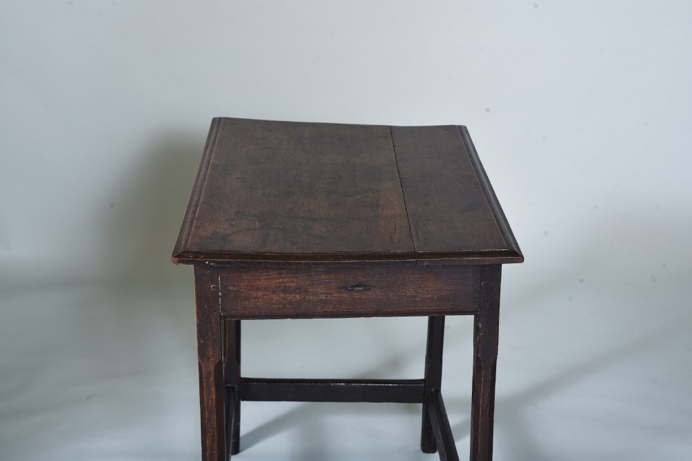 An early eighteenth-century dark oak side table with square chamfered legs, lower box stretchers, and a flat rectangular top. View VI
