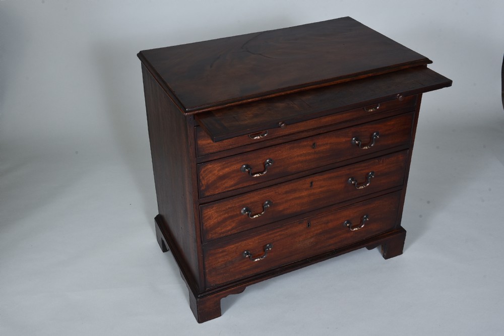 A Georgian mahogany chest of drawers featuring four graduated long drawers with brass swan-neck handles, a pull-out brushing slide, and bracket feet. View III