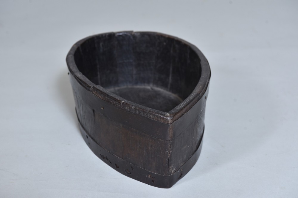 A dark brown teardrop-shaped antique wooden treen vessel bound with iron hoops. View II