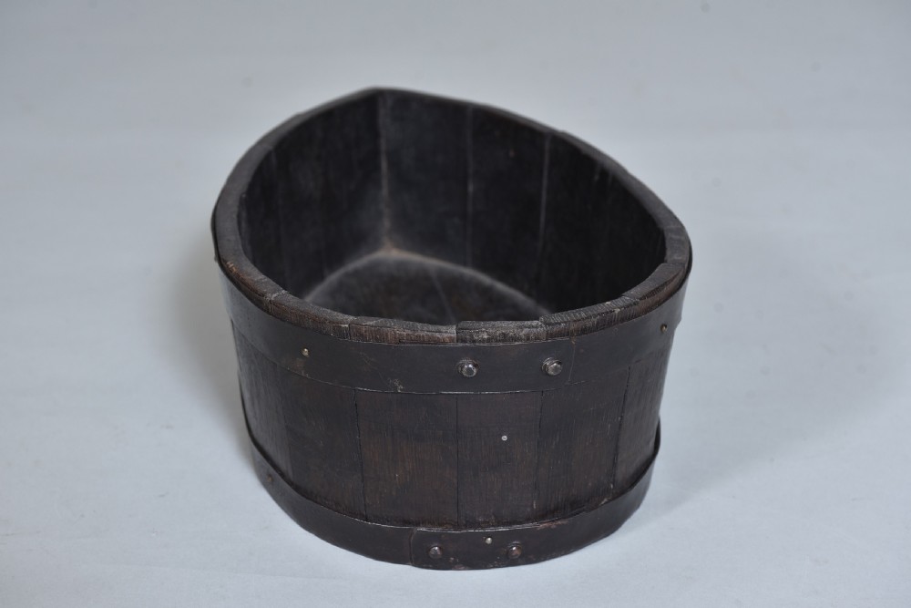 A dark brown teardrop-shaped antique wooden treen vessel bound with iron hoops. View III