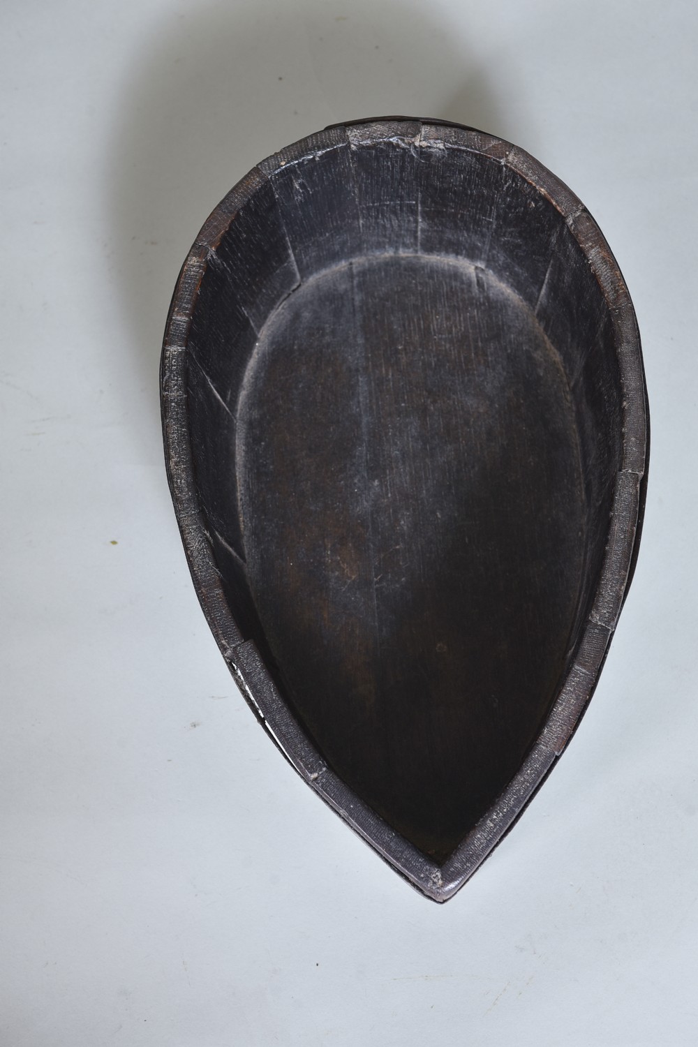 A dark brown teardrop-shaped antique wooden treen vessel bound with iron hoops. View IV