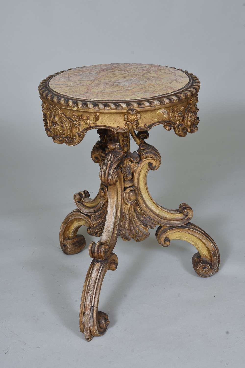 A 19th-century circular side table featuring a mottled marble top, intricate carved giltwood apron, and a scrolled tripod support base. View II