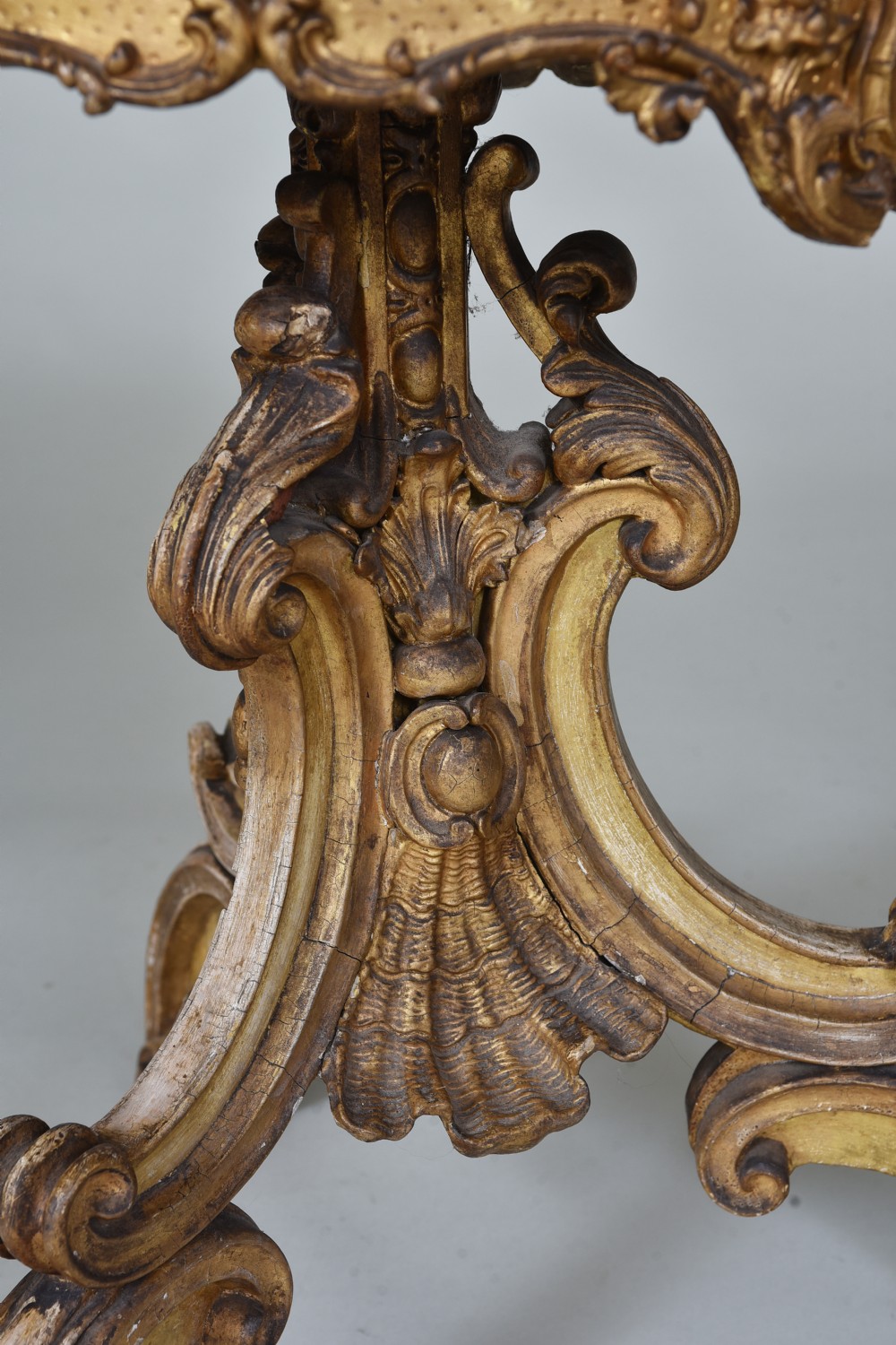 A 19th-century circular side table featuring a mottled marble top, intricate carved giltwood apron, and a scrolled tripod support base. View III