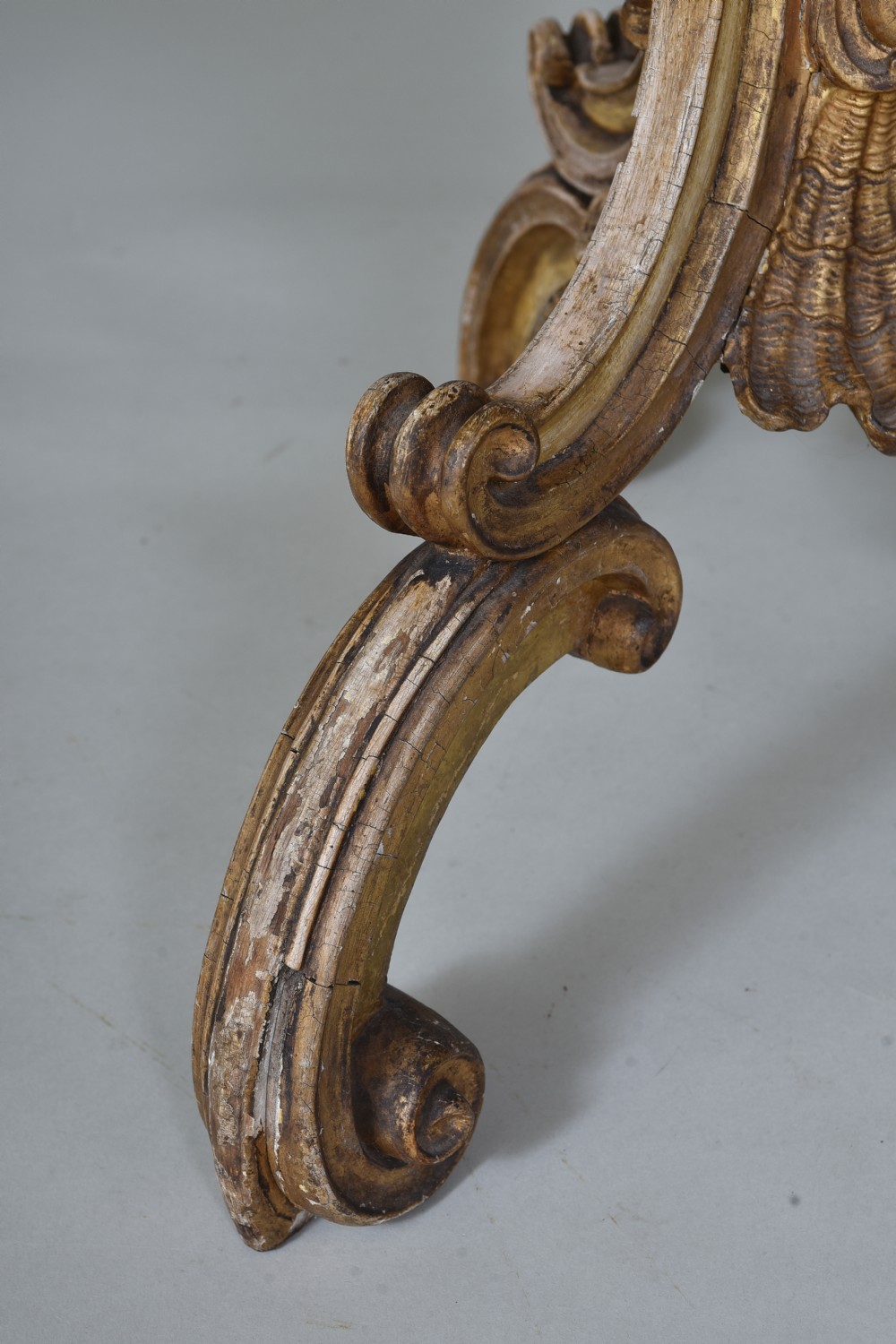A 19th-century circular side table featuring a mottled marble top, intricate carved giltwood apron, and a scrolled tripod support base. View V