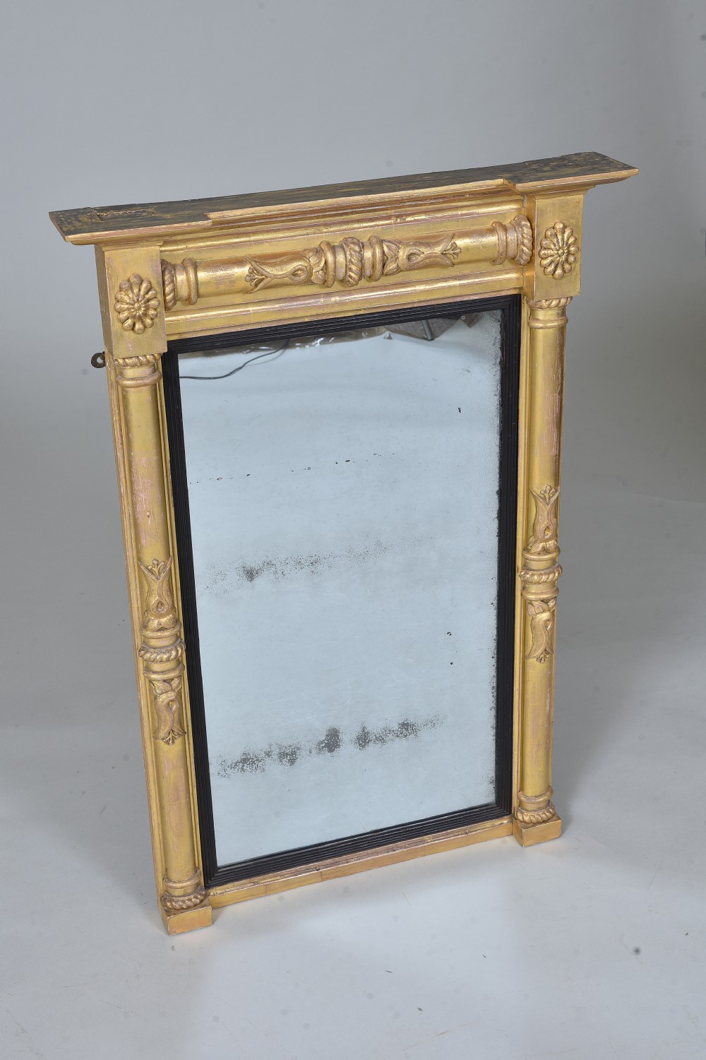 A rectangular Regency giltwood wall mirror featuring side columns, rosette medallions, an ornamental frieze, and an ebonised inner slip. View II