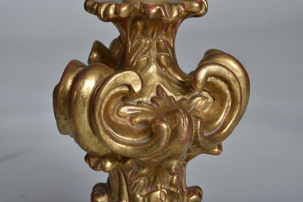 An antique carved giltwood table lamp base featuring scrollwork, acanthus leaf motifs, and a cream faux-candle fitting at the top. View V