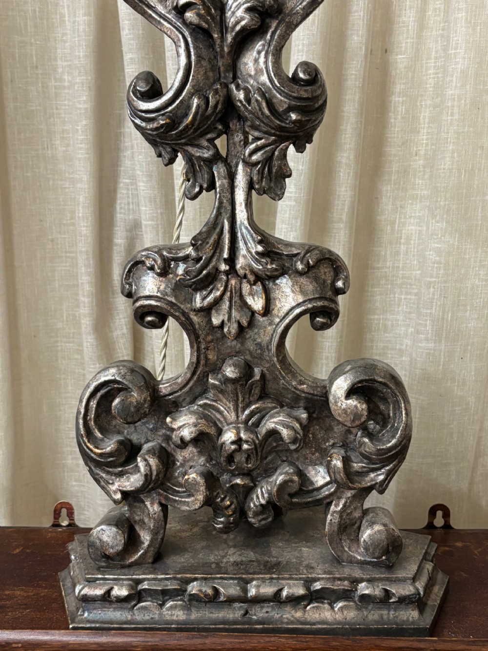 A tall, hand-carved wooden lamp base featuring Baroque scrollwork and an antiqued silver leaf finish. View II